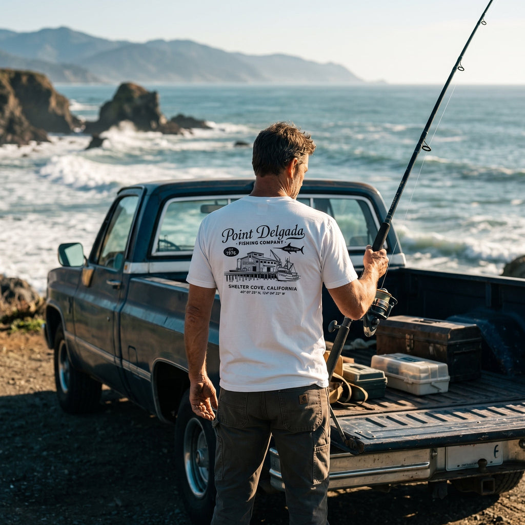Back: White Point Delgada Home Port T-Shirt with black fish house, pier, fishing boat and Shelter Cove, California coordinates graphic