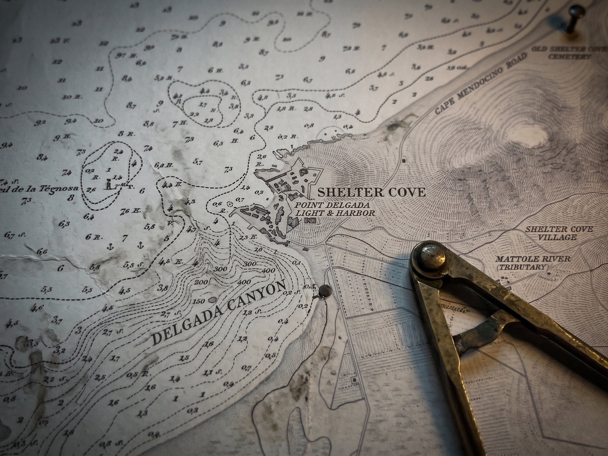 Vintage nautical map of Shelter Cove California with compass and pen on top
